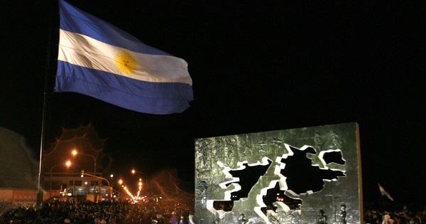 An Argentine flag next to a statue commerating the 1982 war in the Malvinas