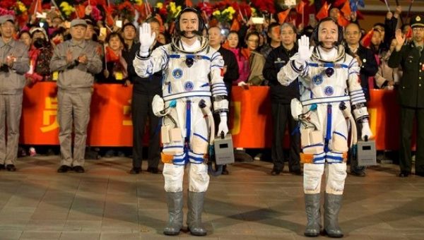 Chinese astronauts Jing Haipeng (R), Chen Dong wave before the launch of Shenzhou-11 manned spacecraft, in Jiuquan, China, Oct. 17, 2016
