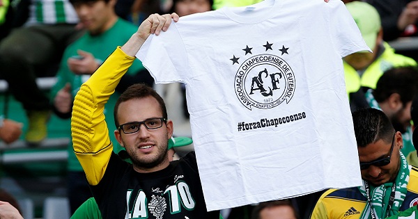 A fan holds a T-shirt for the victims of the Colombia plane crash containing the Chapecoense players and staff before the match.