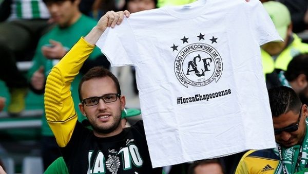 A fan holds a T-shirt for the victims of the Colombia plane crash containing the Chapecoense players and staff before the match. 