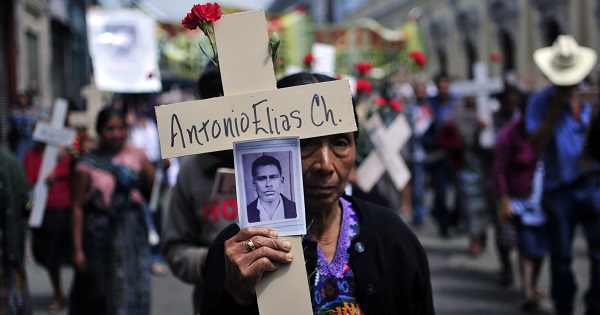 A Mayan woman carries a photo of her husband, who was disappeared by the Guatemalan army in 1982, during an event in Guatemala City, Feb. 25, 2010.