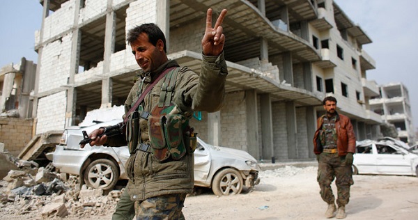 A fighter of the Kurdish People's Protection Units flashes a V-sign as he patrols in the streets in the northern Syrian town of Kobane.