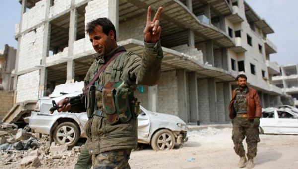 A fighter of the Kurdish People's Protection Units flashes a V-sign as he patrols in the streets in the northern Syrian town of Kobane.
