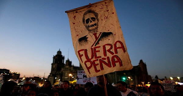 A demonstrator holds a placard depicting Mexican President Enrique Pena Nieto during a protest against a fuel price hike in Mexico City, Mexico January 9, 2017.