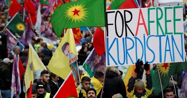 Members of the Kurdish community hold banner and flags during a rally in front of the Gare du Nord railway station in Paris, France, Jan. 7, 2017.