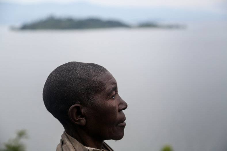 Habimana, 45, poses for a portrait at Kagorwa Pygmy camp. She weeds the fields of a Bahavu businessman building a hotel on the coast, but earns only one-third as much as other workers, and has to sell pottery at market to make extra money. 