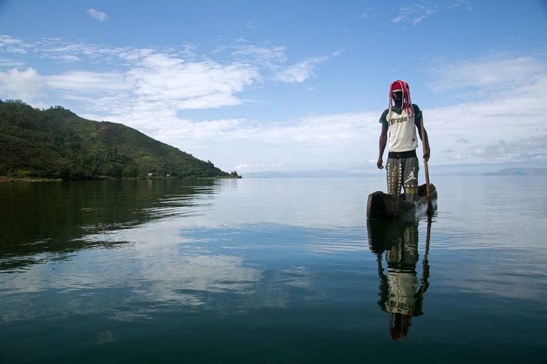 Manguiste, 24, stands in a canoe on Lake Kivu. He says  he has given up on the old Bambuti existence: 