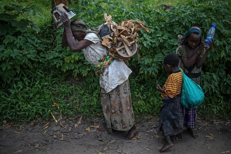 Habimana, 45, and her children walk to market to sell pottery. 
