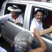 Honduras' former President Manuel Zelaya and his wife Xiomara Castro de Zelaya greet supporters from a car in Tegucigalpa in 2012. 