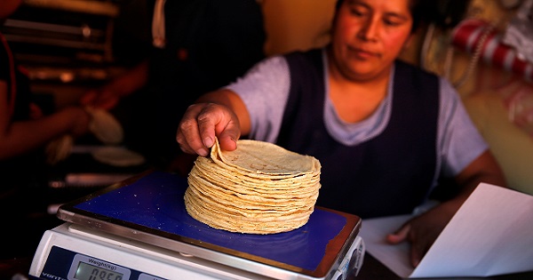 An employee weighs tortillas outside Granada market in Mexico City, Mexico, January 10, 2017.