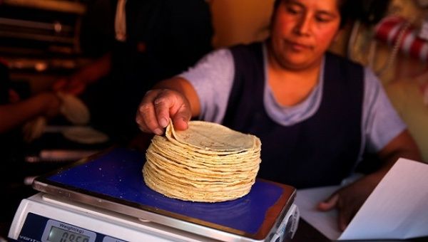 An employee weighs tortillas outside Granada market in Mexico City, Mexico, January 10, 2017. 