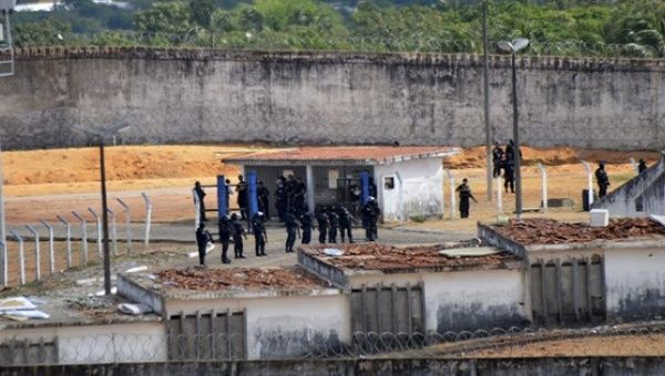 Police patrol the Alcazuz prison, in the Brazilian city of Natal, after a riot left at least 10 inmates dead.