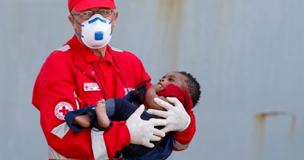A member of the Italian Red Cross holds a child after disembarking from the Italian Navy vessel Aviere in the Sicilian harbor of Augusta, June 10, 2016.