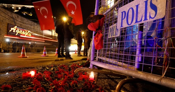 Flowers are placed in front of a police barrier near the entrance of Reina nightclub in Istanbul, Turkey, which was attacked by a gunman.