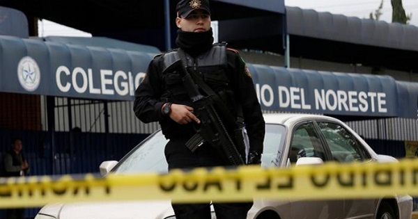 A police officer stands outside the Colegio Americano del Noreste after a student opened fire at the American school in Monterrey, Mexico.