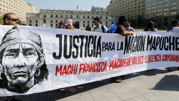 Mapuche Indian activists hold up a placard with the image of Francisca Linconao, who is an inmate, that reads 