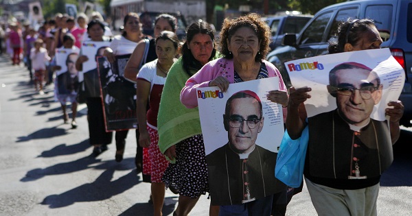 Victims of El Salvador's civil war march with signs of Romero, Dec.16, 2014.