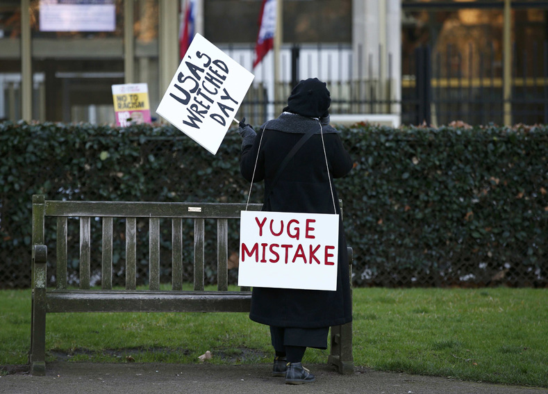 A demonstrator holds a banner during a protest against the inauguration of Donald Trump as U.S. President, outside the U.S. embassy in London, Britain, Jan. 20, 2017.
