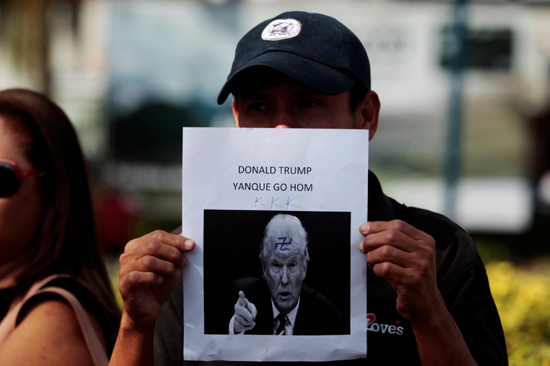 A Salvadoran worker holds a picture of U.S. President-elect Donald Trump with the words, 