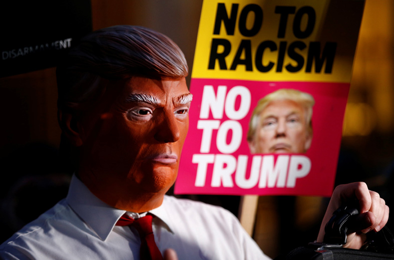A demonstrator wears a mask during a protest against the inauguration of Donald Trump as U.S. President outside the U.S. embassy in London, Britain, Jan. 20, 2017.