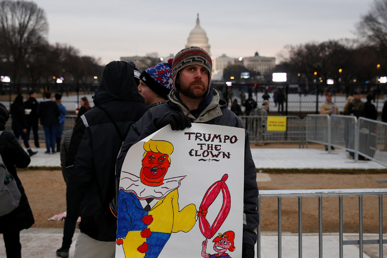 A demonstrator against U.S. President-elect Donald Trump stands in the foreground of the U.S. Capitol on the National Mall before Trump is to be sworn in Washington, D.C., Jan. 20, 2017. 