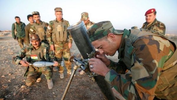Peshmerga forces prepare to launch a mortar during preparations to attack Mosul, in the town of Naweran near Mosul, Iraq.