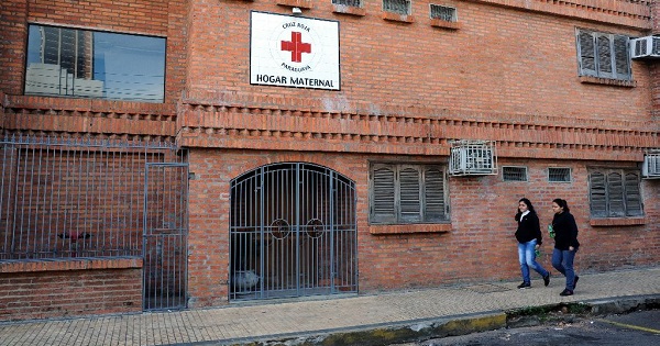 Women walk past a Red Cross maternity home in Asuncion, Paraguay.