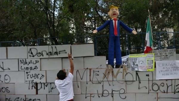 An activist works on a symbolic wall built by protesters outside the US embassy in Mexico City, Mexico.
