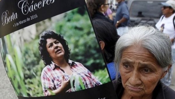 A woman with a poster of slain environmental activist Berta Caceres.