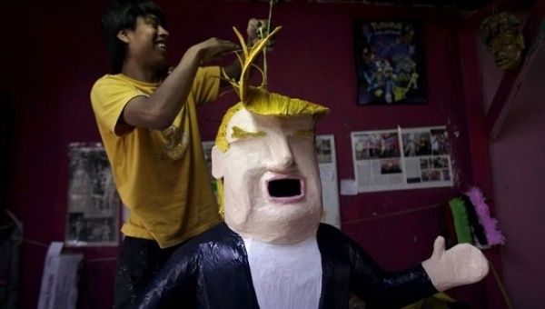 Worker hanging a piñata of U.S. President Donald Trump