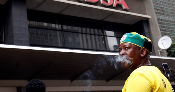 A member of the African National Congress Youth League protests in front of ABSA Bank against an apartheid-era bailout, Jan. 26, 2017.