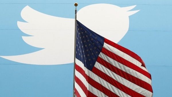 The Twitter Inc. logo is shown with the U.S. flag during the company's IPO on the floor of the New York Stock Exchange in New York, Nov. 7, 2013.
