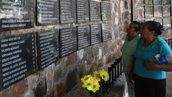 Women observe a mural with the names of the campesinos murdered by the Armed Forces in El Mozote, El Salvador, in 1981.