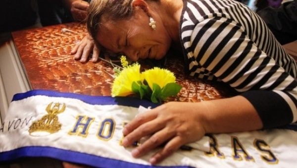Teresa Munoz mourns over the coffin of her daughter Maria Jose Alvarado during a wake for her and her sister Sofia in Honduras, Nov. 20, 2014.