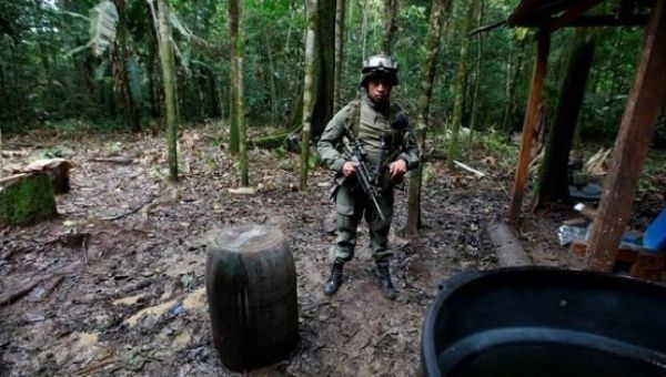 A Colombian anti-narcotics policeman guards a cocaine lab, which, according to authorities, belongs to criminal gangs in Guaviare state, Aug. 2, 2016.