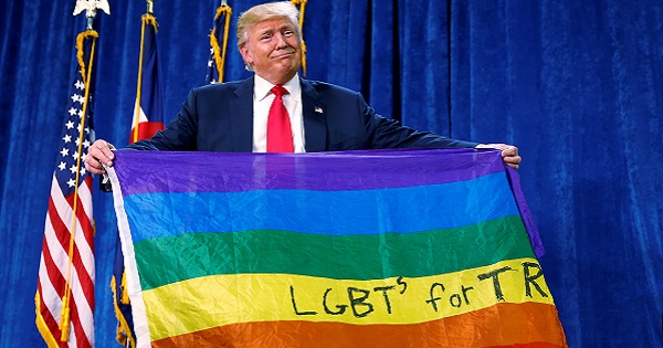 Donald Trump holds up a rainbow flag with 