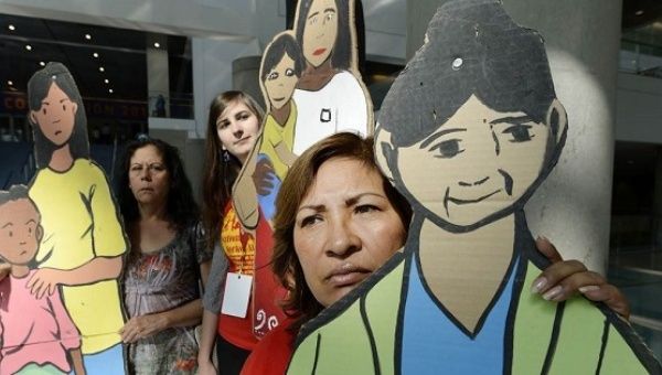 National Domestic Workers Alliance organizers holding cardboard cutouts during a Los Angeles news conference.