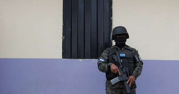 A military policeman keeps watch outside a house during an operation in Tegucigalpa, Honduras, Jan. 30, 2017.