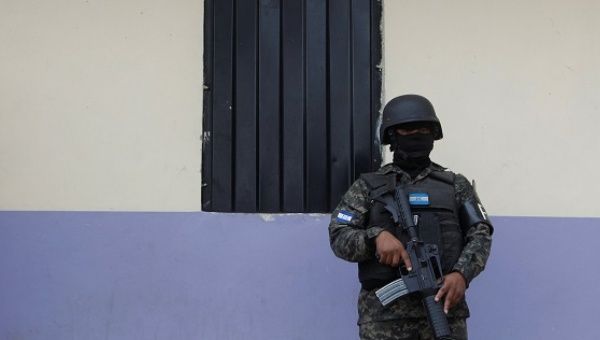 A military policeman keeps watch outside a house during an operation in Tegucigalpa, Honduras, Jan. 30, 2017.