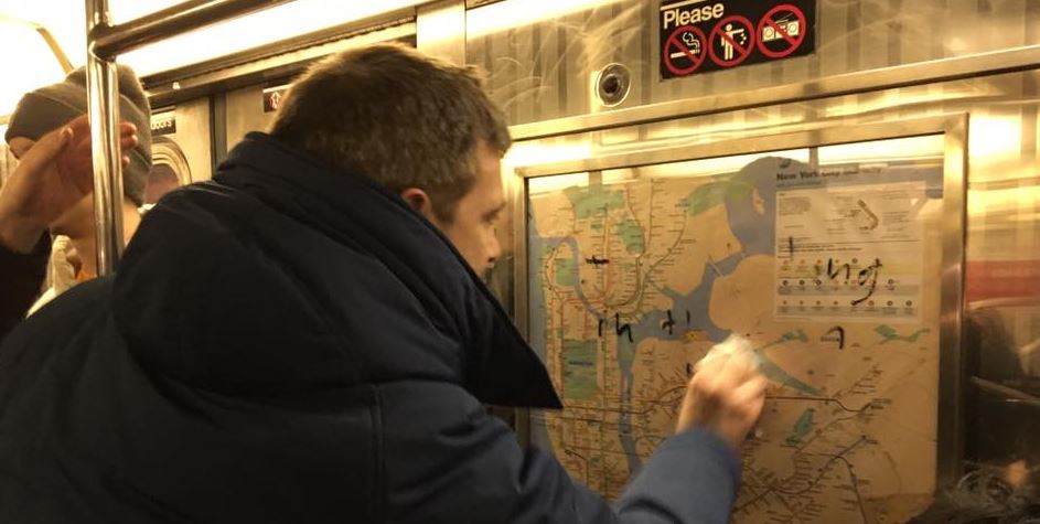 A New York subway passenger cleans anti-Semitic graffiti on a train car.