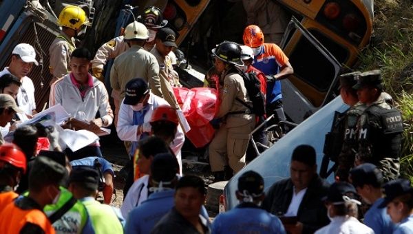 Rescue workers and members of the red cross carry a body after a crash between a bus and a truck on the outskirts of Tegucigalpa, Honduras, Feb. 5, 2017.