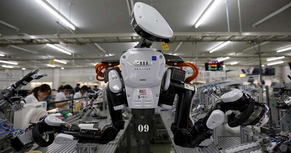 A humanoid robot works side by side with employees in the assembly line at a factory of Glory Ltd., in Kazo, north of Tokyo.