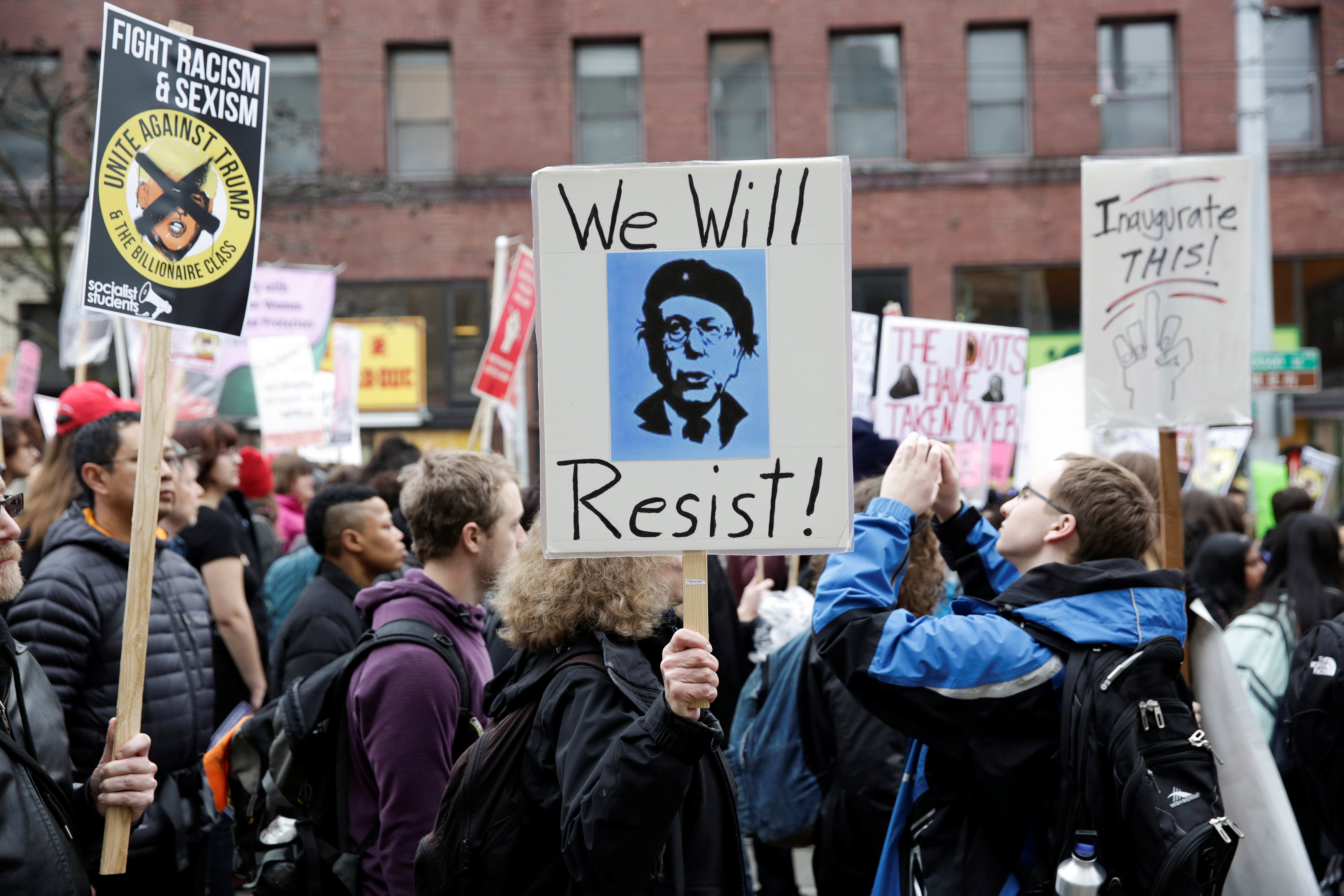 A photo of U.S. Senator Bernie Sanders is pictured on a demonstrator's sign as people march to protest U.S. President Donald Trump in Seattle, Washington.