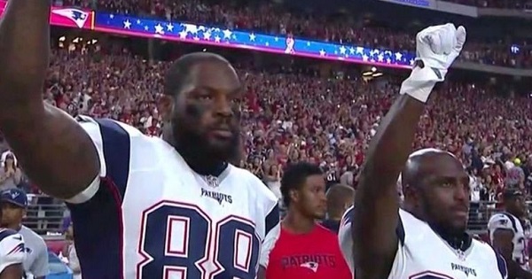 New England Patriots Martellus Bennett (L) and Devin McCourty (R) raise fists in protest during the U.S. national anthem, Sept. 11, 2016.