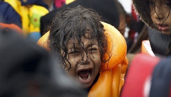 A Syrian refugee child screams inside an overcrowded dinghy after crossing part of the Aegean Sea from Turkey to the Greek island of Lesbos Sept. 23, 2015.