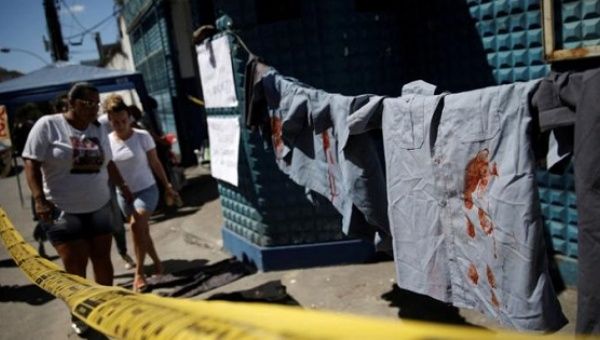 Uniforms placed by family of police officers in protest for better salaries hang by the entrance of the military police battalion in Rio de Janeiro, Feb. 10, 2017.