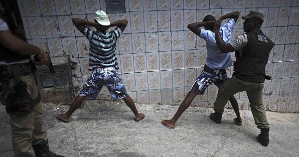 Police search youths for weapons and drugs while on patrol in the Nordeste de Amaralina slum complex in Salvador, Bahia State.