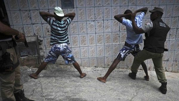 Police search youths for weapons and drugs while on patrol in the Nordeste de Amaralina slum complex in Salvador, Bahia State.