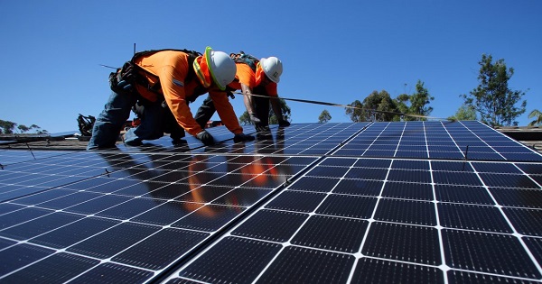 Workers installing solar panels on a home in San Diego, California