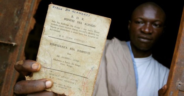 A resident holds up a Bundu dia Kongo manifesto left behind after a police crackdown on the religious and political movement in Matadi in 2008.